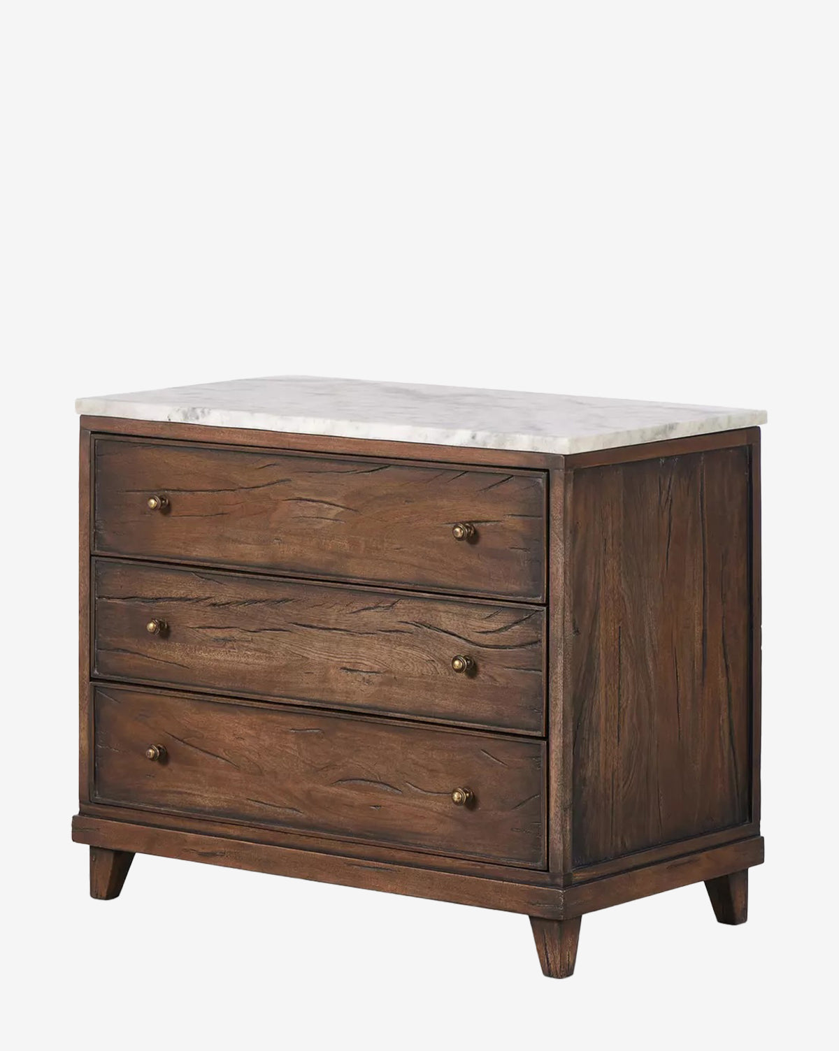 The Bettiga Nightstand features three drawers with brass hardware, a white marble top, and is crafted from antique reclaimed wood in a rich dark finish with visible grain, standing on four short angled legs by McGee & Co.