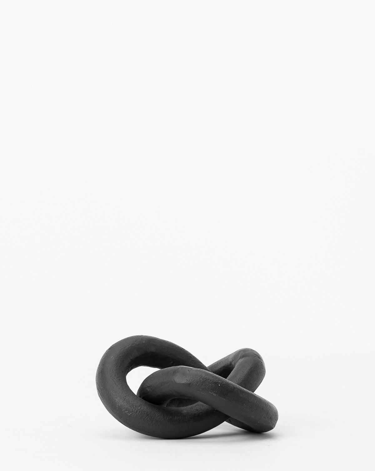The Black Infinity Loop is a black, twisted ceramic sculpture with an abstract knot-like form, displayed on a plain white background—an ideal modern home accessory.