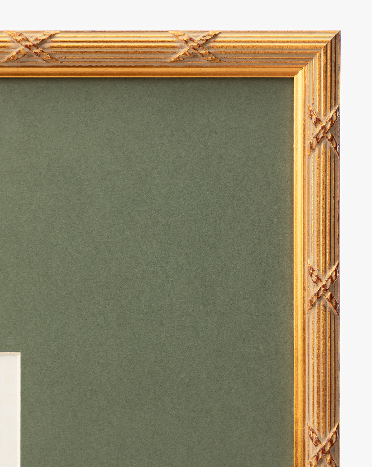 Close-up of the top right corner of the Botanical Grid 2 art frame, featuring X-shaped gold carvings set against a green matte background, by McGee & Co.