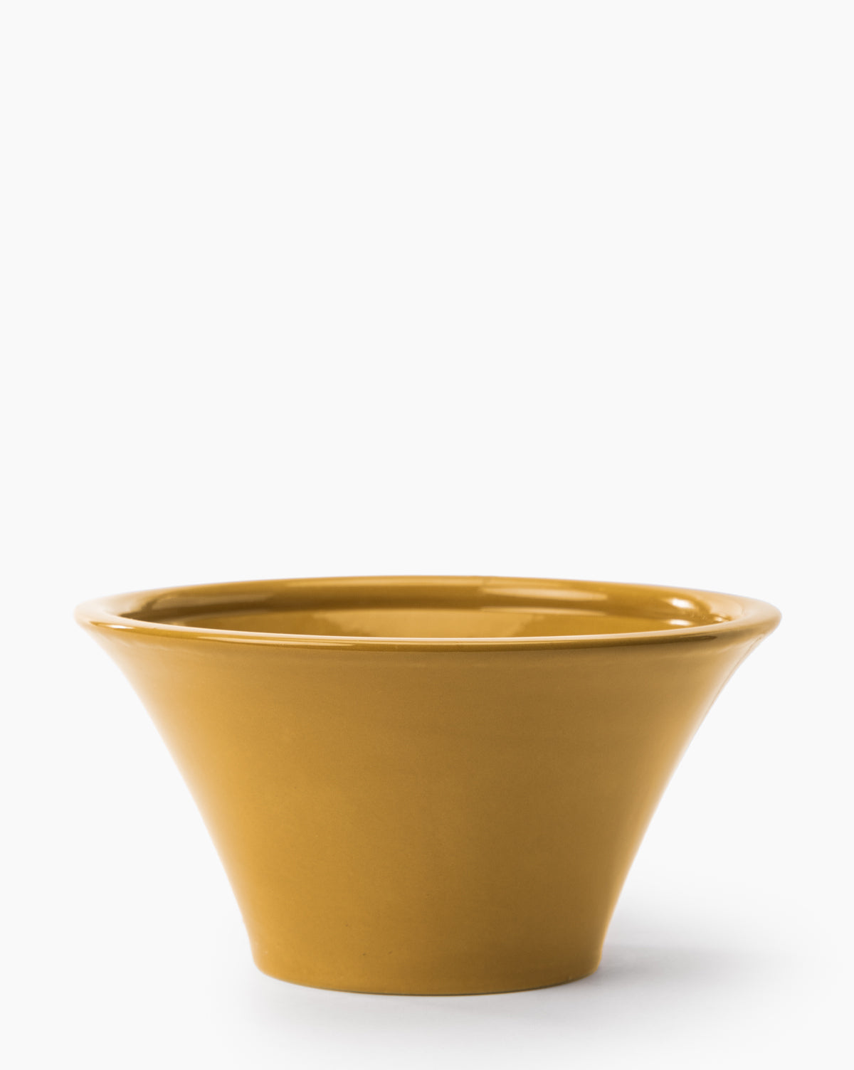 The Brennan Serving Bowl, featuring a wide rim and narrow base in mustard yellow ceramic, adds a vibrant touch to your kitchen decor. Photographed against a plain white background by McGee & Co.