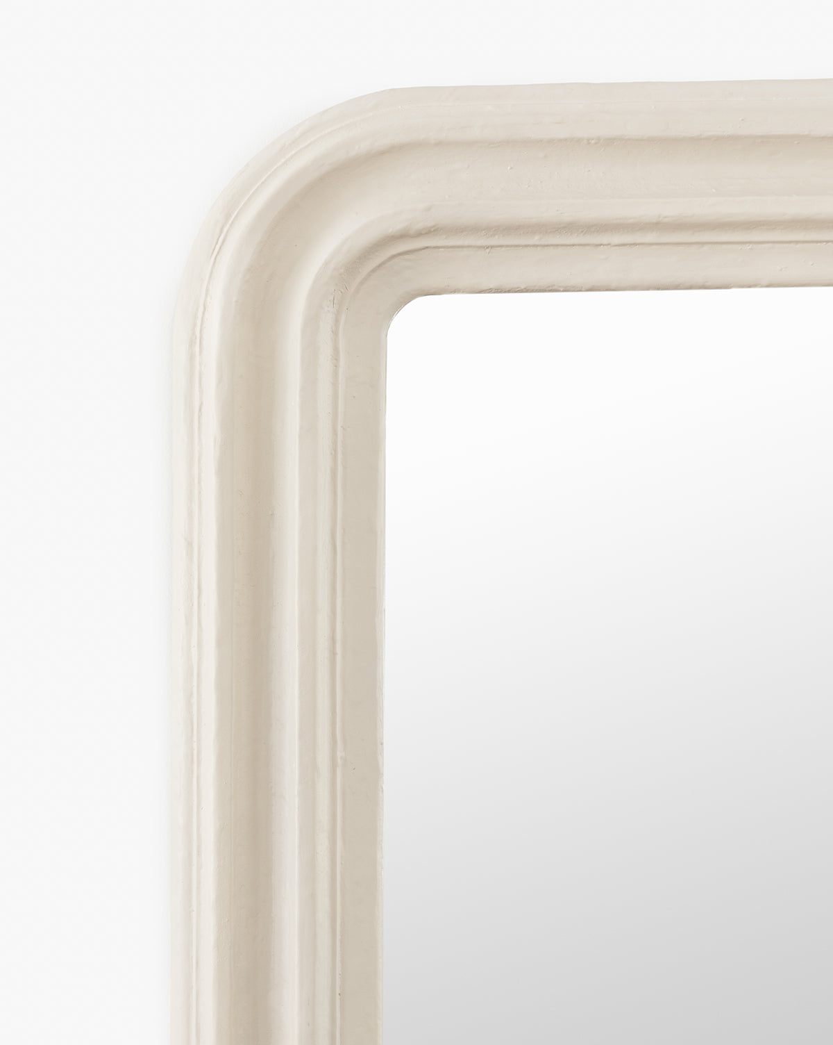 Close-up of the Breslin Floor Mirrors top left corner, highlighting its smooth, thick rounded cream frame with a plaster finish, set against a white background by McGee & Co.