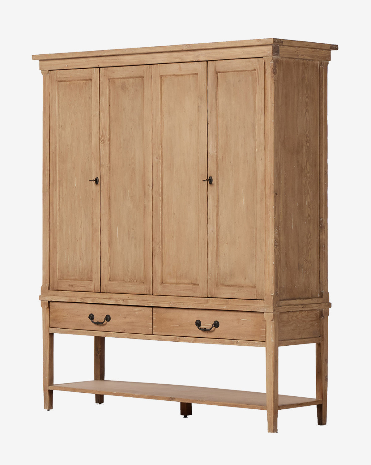 The Bryn Cabinet is a large solid pine armoire with four paneled doors, two drawers featuring distressed copper hardware, and an open bottom shelf in a light natural wood finish, by McGee & Co.
