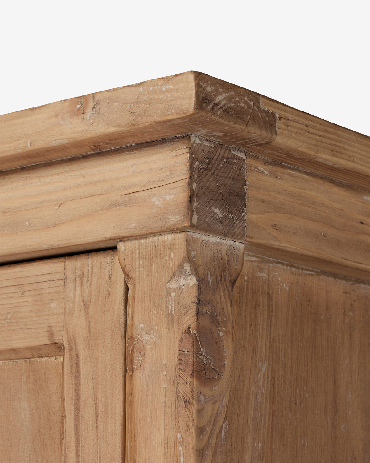Close-up of the Bryn Cabinets top corner, made from solid pine, highlighting natural wood grain, knots, and joinery in a rustic, unfinished style against a white background, by McGee & Co.