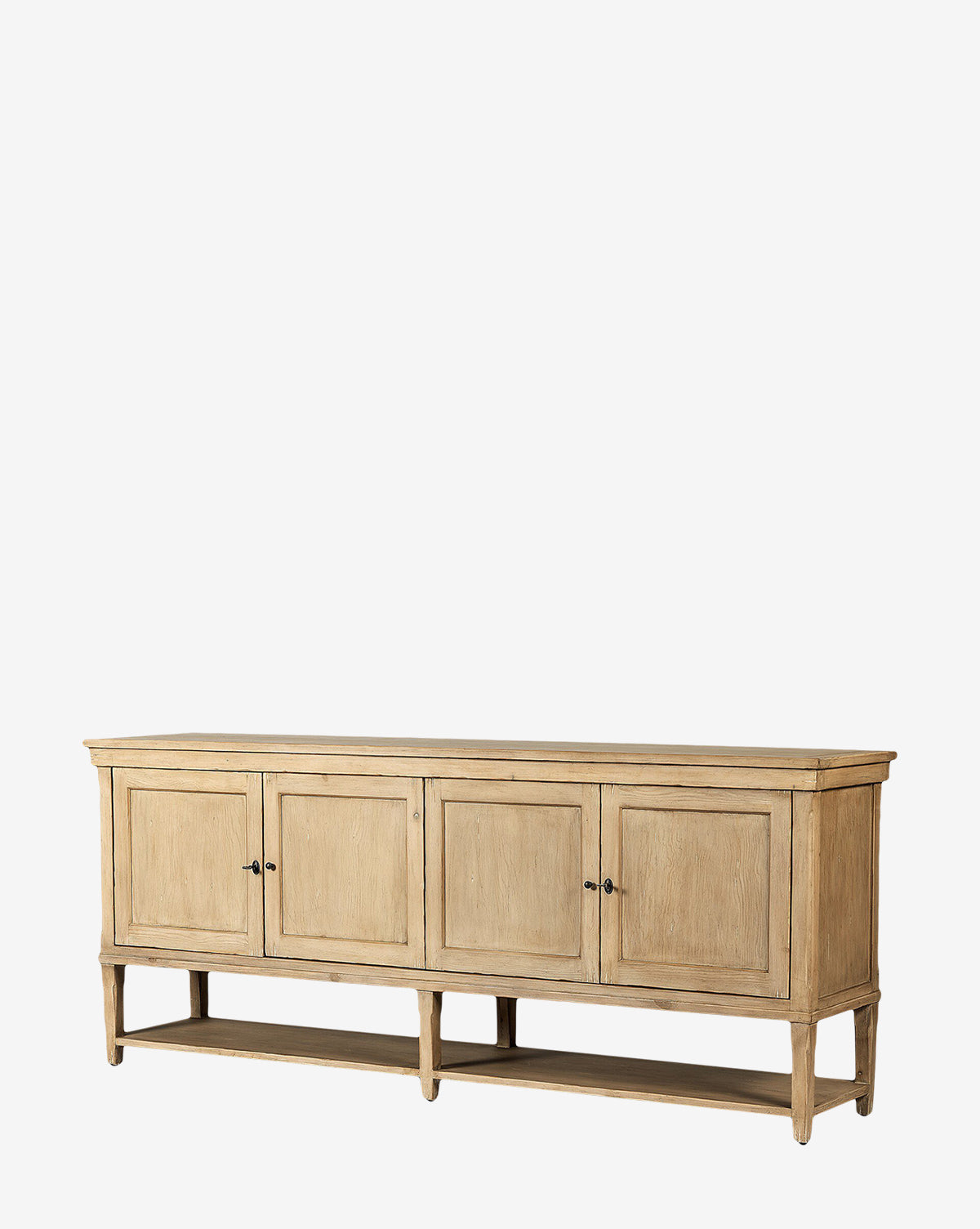 The Bryn Sideboard is crafted from solid pine with a natural finish, featuring four paneled doors, distressed copper hardware, an open lower shelf, and elegant tapered legs in a simple rectangular design, by McGee & Co.