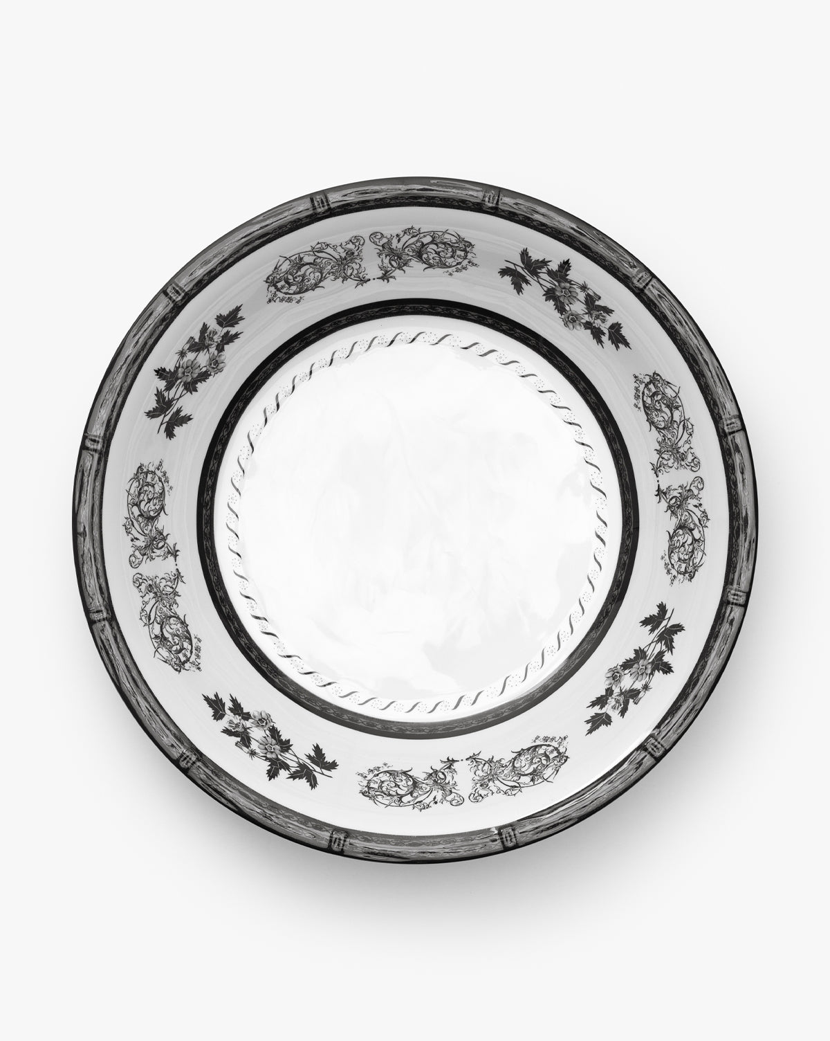 The Calanthe Melamine Serving Bowl features an ornate black floral and leaf pattern around the rim with a simple rope-like design at the center, reminiscent of vintage styles, by McGee & Co. Presented from above against a plain white background.