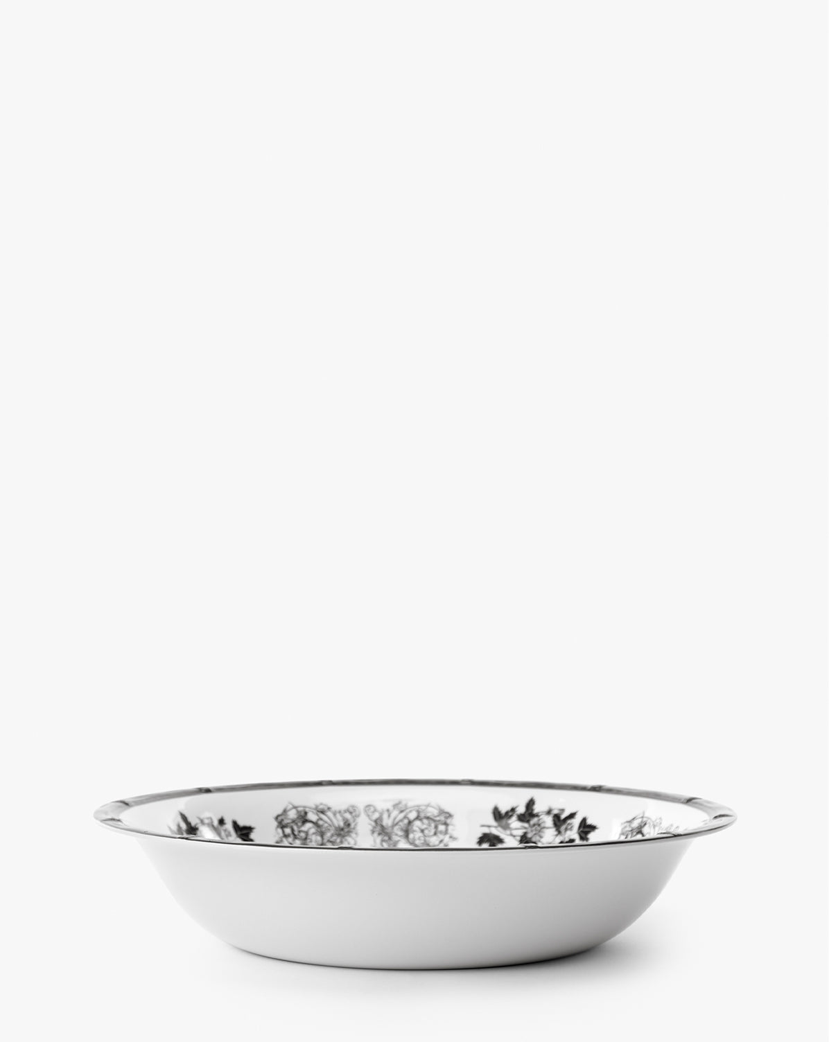 The Calanthe Melamine Serving Bowl features vintage-inspired black floral designs on white, a silver rim, and is shatter-resistant, making it perfect for elegant displays, by McGee & Co.