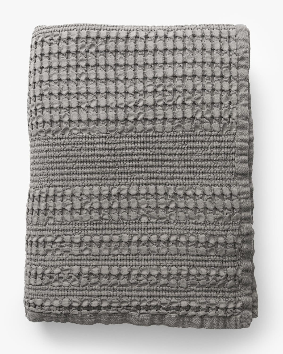 The Penedo Carnel Gray Waffle Blanket features a textured, woven checkered pattern with raised detailing and is shown folded on a white background from McGee & Co.