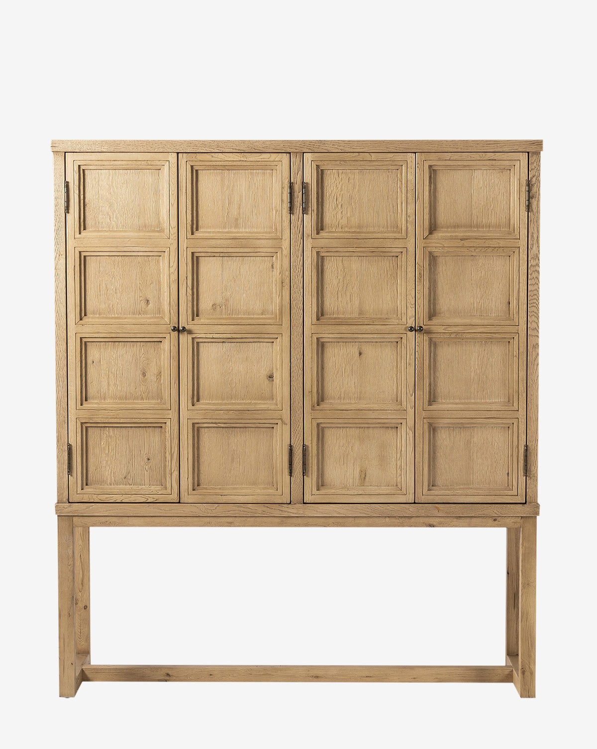 The Carrington Cabinet showcases double doors with a geometric square pattern, four straight legs, an open lower section, worn oak construction, bronze-finished hardware, and a natural light finish, by McGee & Co.