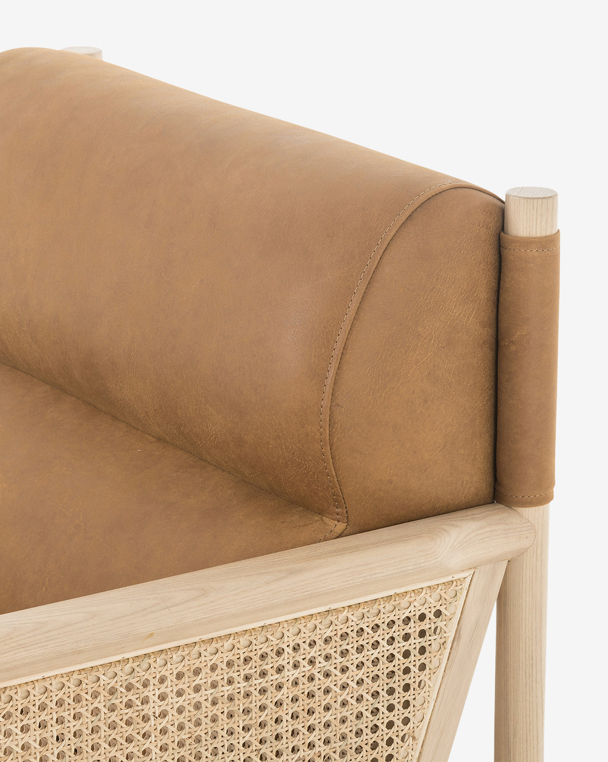 The Channing Lounge Chair showcases a light wood frame, tan leather cushion, high-performance upholstery, and woven cane side panels, all set against a white background with Parisian-inspired design by McGee & Co.