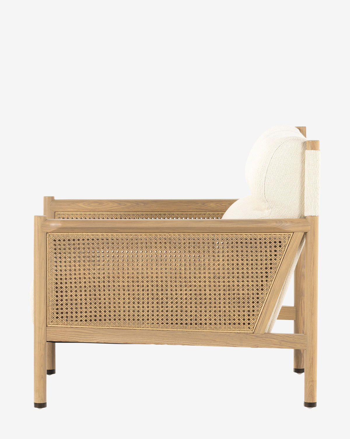 A side view of the Channing Lounge Chair shows its Parisian style, wooden frame, cane paneling, and cream high-performance upholstered seat, all set against a plain white background by McGee & Co.