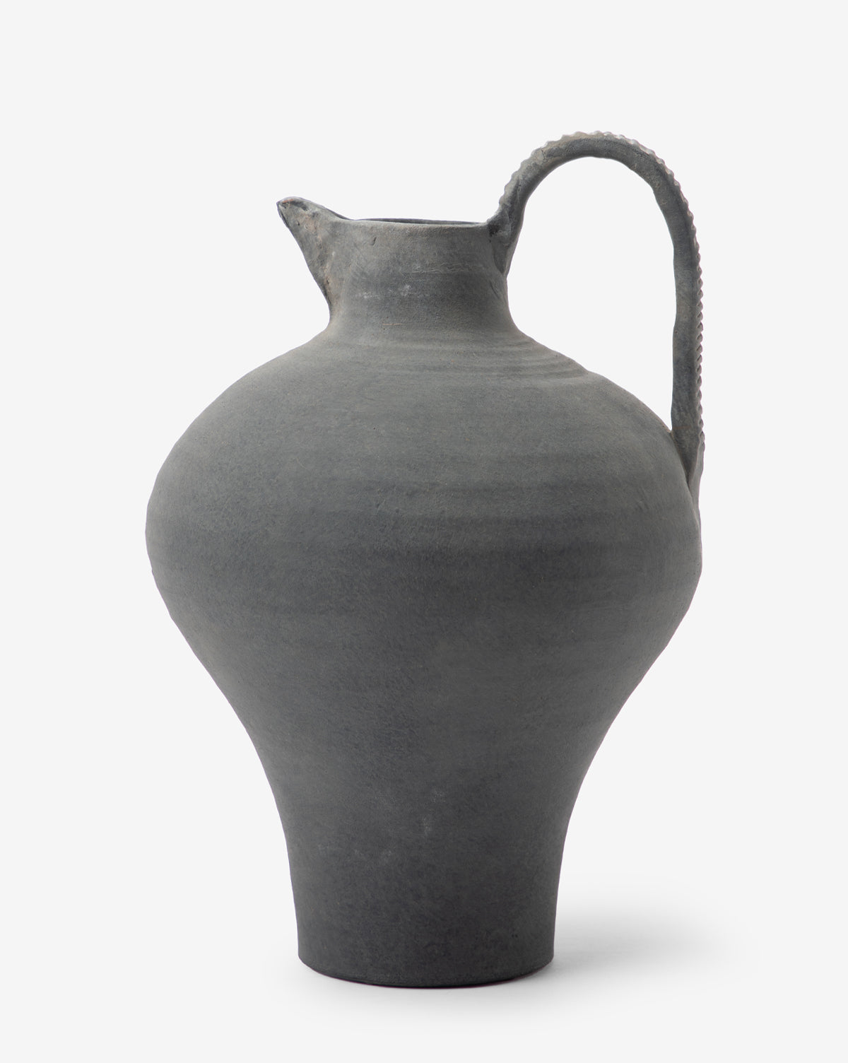 The Charcoal Terracotta Jug is a handmade gray ceramic piece with a rounded body, narrow neck, single textured handle, small spout, and matte slightly rough finish.