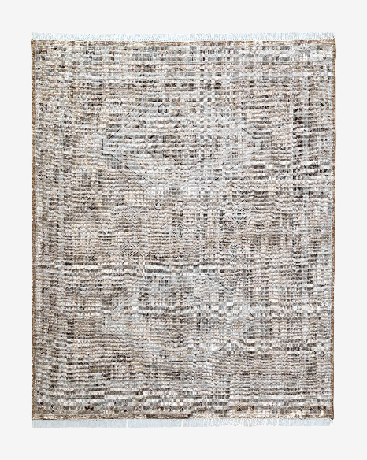 The Charlot Hand-Knotted Rug is a rectangular vintage piece with a faded geometric and floral pattern in beige and light brown, a central medallion, subtle border, and short fringed edges on two sides, by McGee & Co.