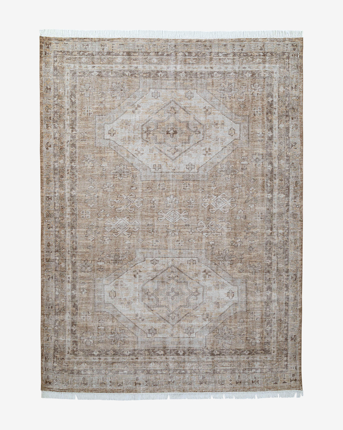 The Charlot Hand-Knotted Rug is a rectangular brown artisan piece featuring a faded geometric and floral design, lighter bordered edges, and short white fringe on the shorter sides, by McGee & Co.
