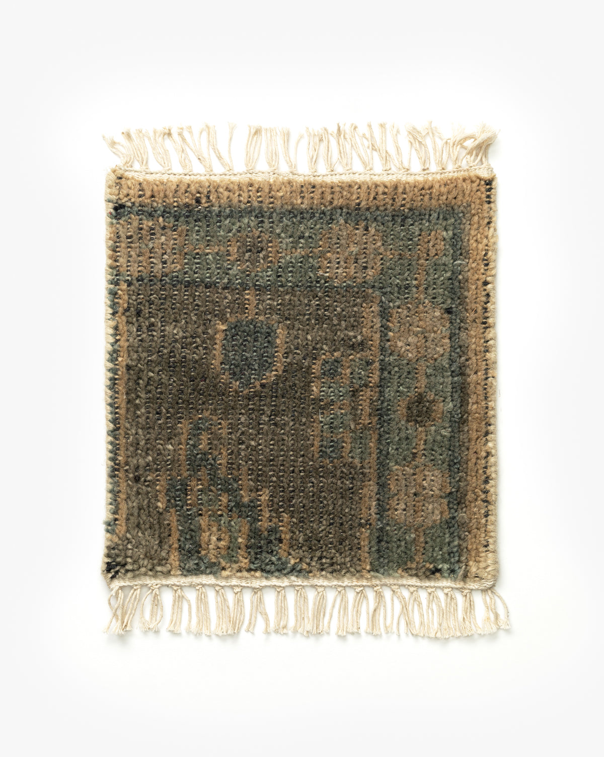 The Chevalier Hand-Knotted Rug Swatch is a small, rectangular wool piece with fringed edges, showcasing a vintage-inspired beige, brown, and green geometric pattern on a plain white background by McGee & Co.