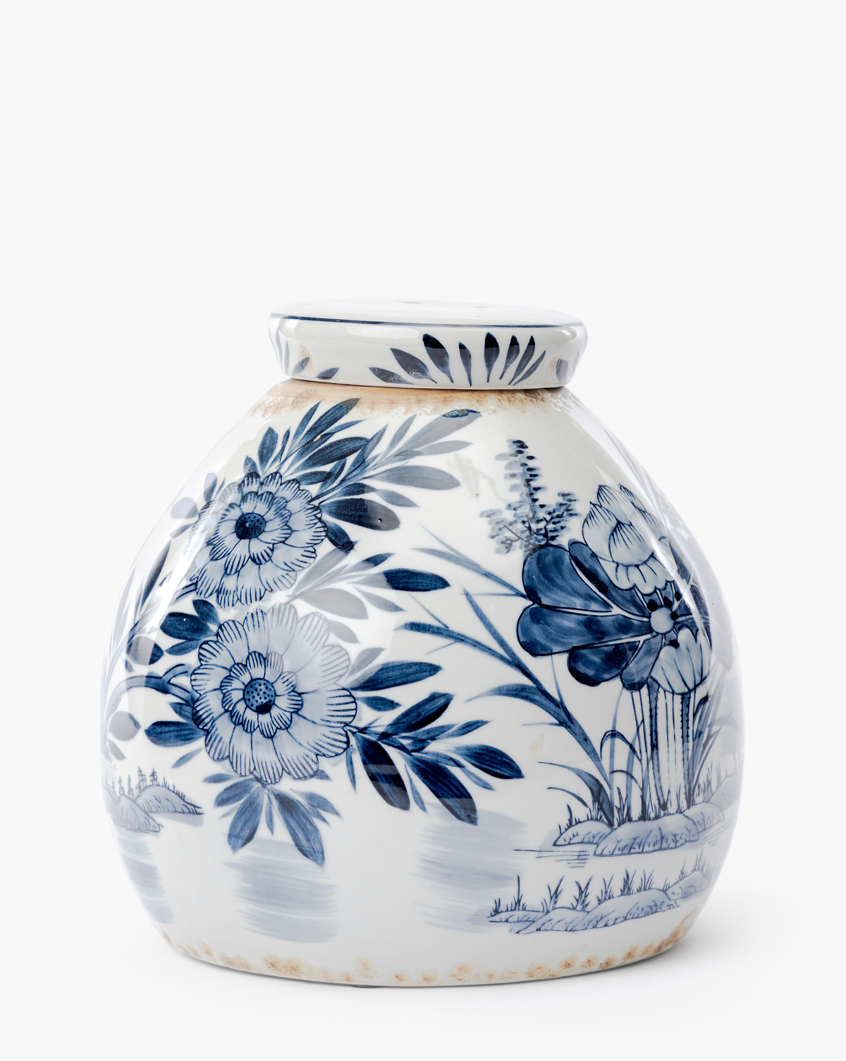 The Chinoiserie Ginger Jar is a round, white ceramic piece with intricate hand-painted blue floral and leaf patterns, detailed with flowers, leaves, and grass. It features a narrow neck and slightly flared rim against a clean white background, by McGee & Co.