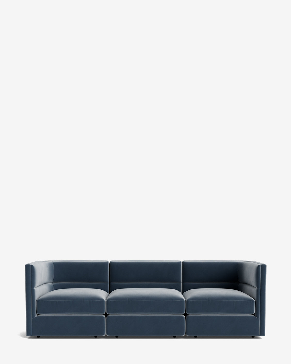 The Claremont Modular Sofa 99 is a modern, low-profile blue velvet sofa with three connected seats, square arms, and a minimalist design for luxurious comfort, displayed against a plain white background by McGee & Co.