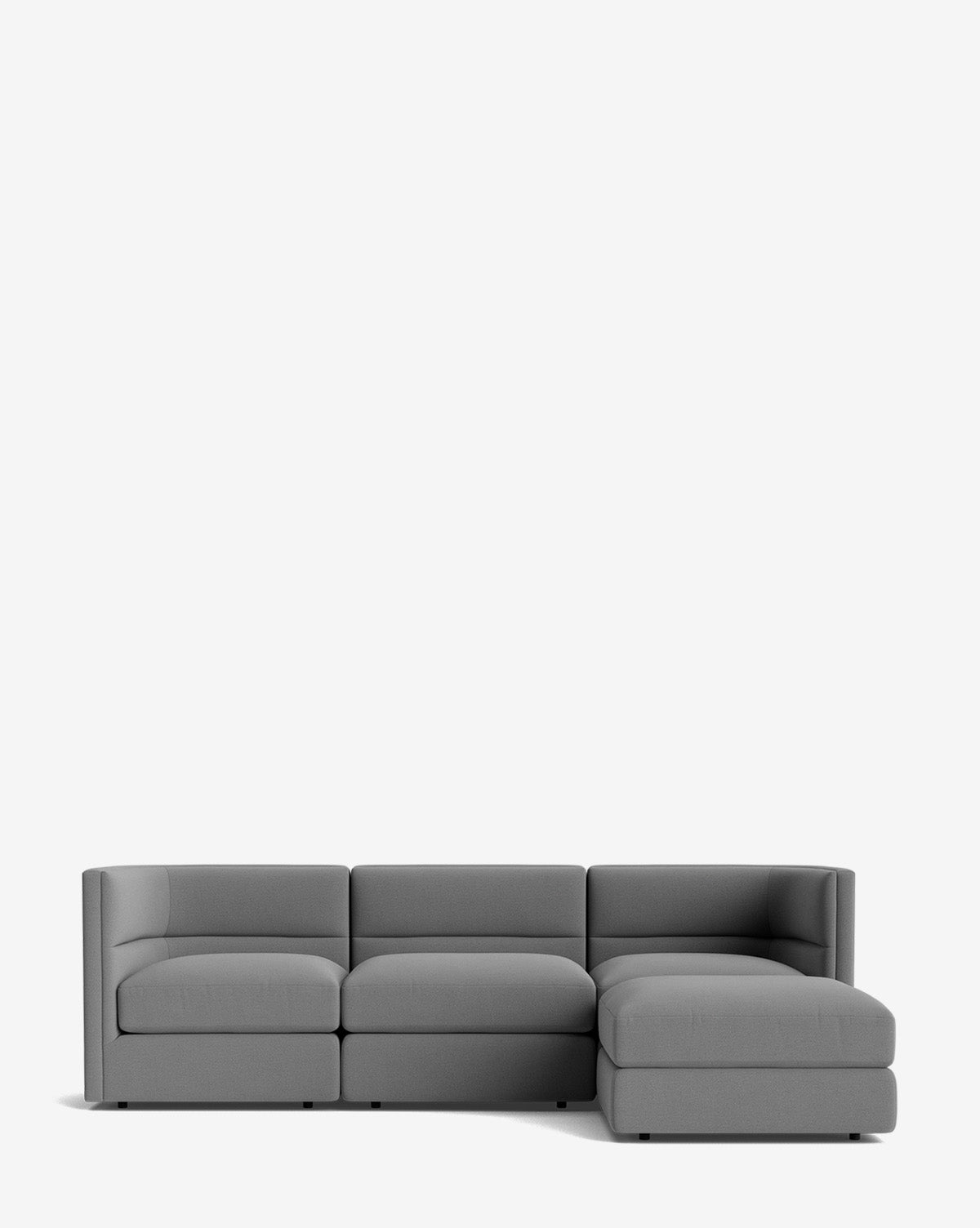 The Makerspalm Claremont Modular Sofa with Ottoman 99 is a modern gray L-shaped design with three seat cushions and a right-side chaise, shown against a plain white background. McGee & Co.