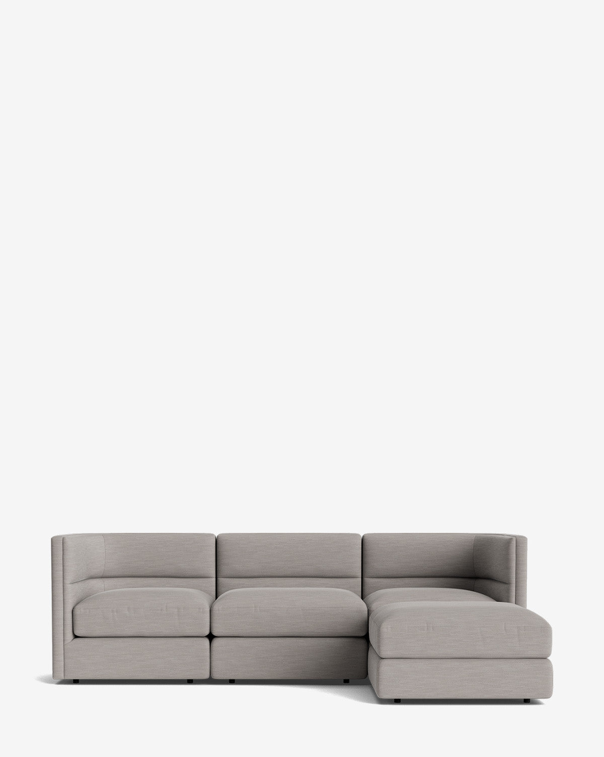 The Claremont Modular Sofa with Ottoman 99 is a modern, light grey piece with channeled back detailing, featuring three seat cushions and a right-facing chaise lounge, shown against a white background by McGee & Co.