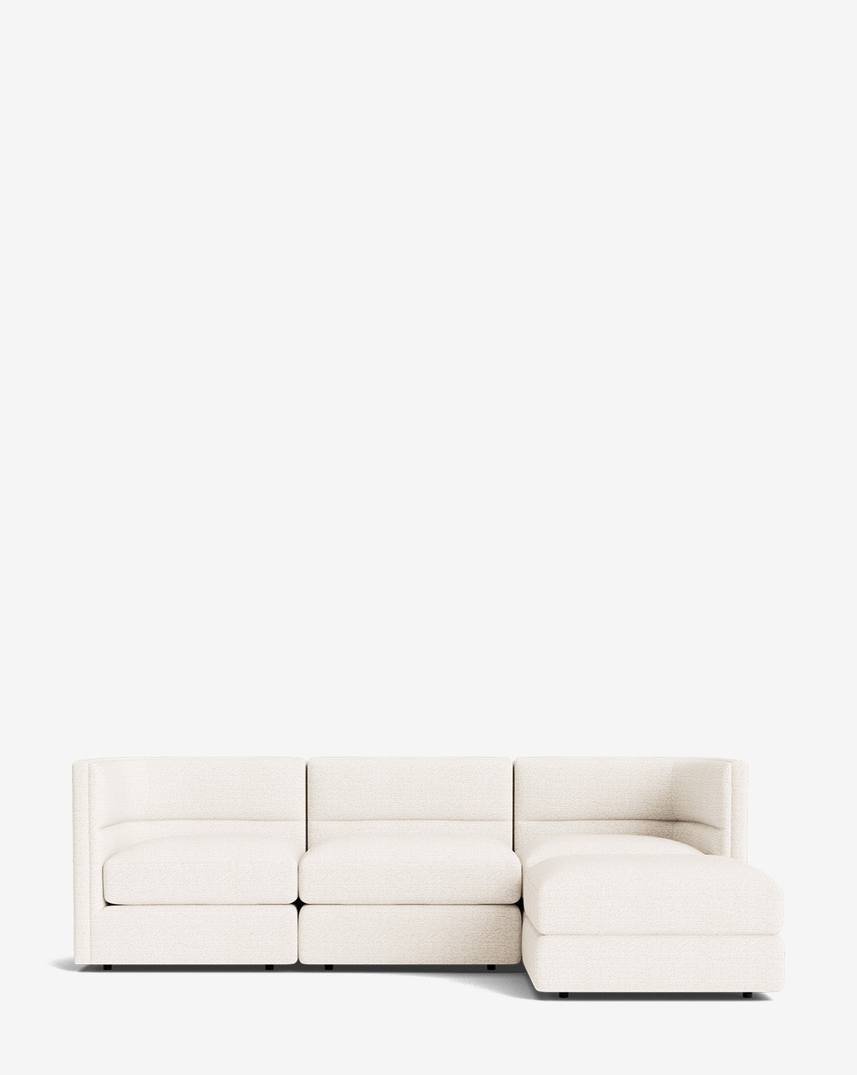 The Makerspalm Claremont Modular Sofa with Ottoman 99 is a modern, low-profile off-white piece featuring three seats and a right-side chaise, shown against a plain white background. McGee & Co.