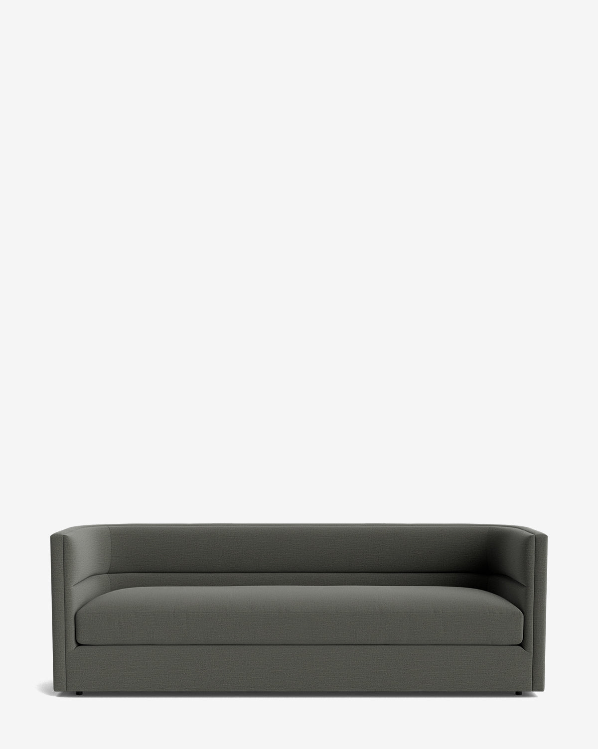 The Claremont Sofa 84 is a modern, dark gray piece featuring a low back and sides, minimalist design, and hidden legs. Upholstered in premium fabric, it is shown against a plain white background, by McGee & Co.