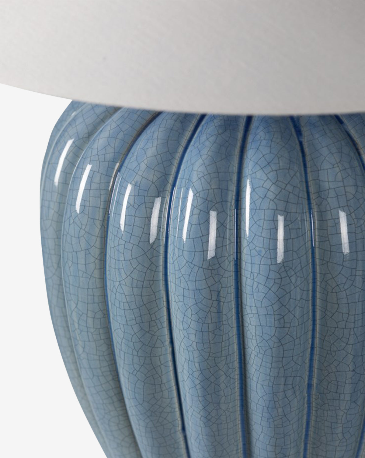 The Clarendon Table Lamp features a ribbed ceramic base with a light blue crackle glaze and is topped with a white lampshade, by McGee & Co.