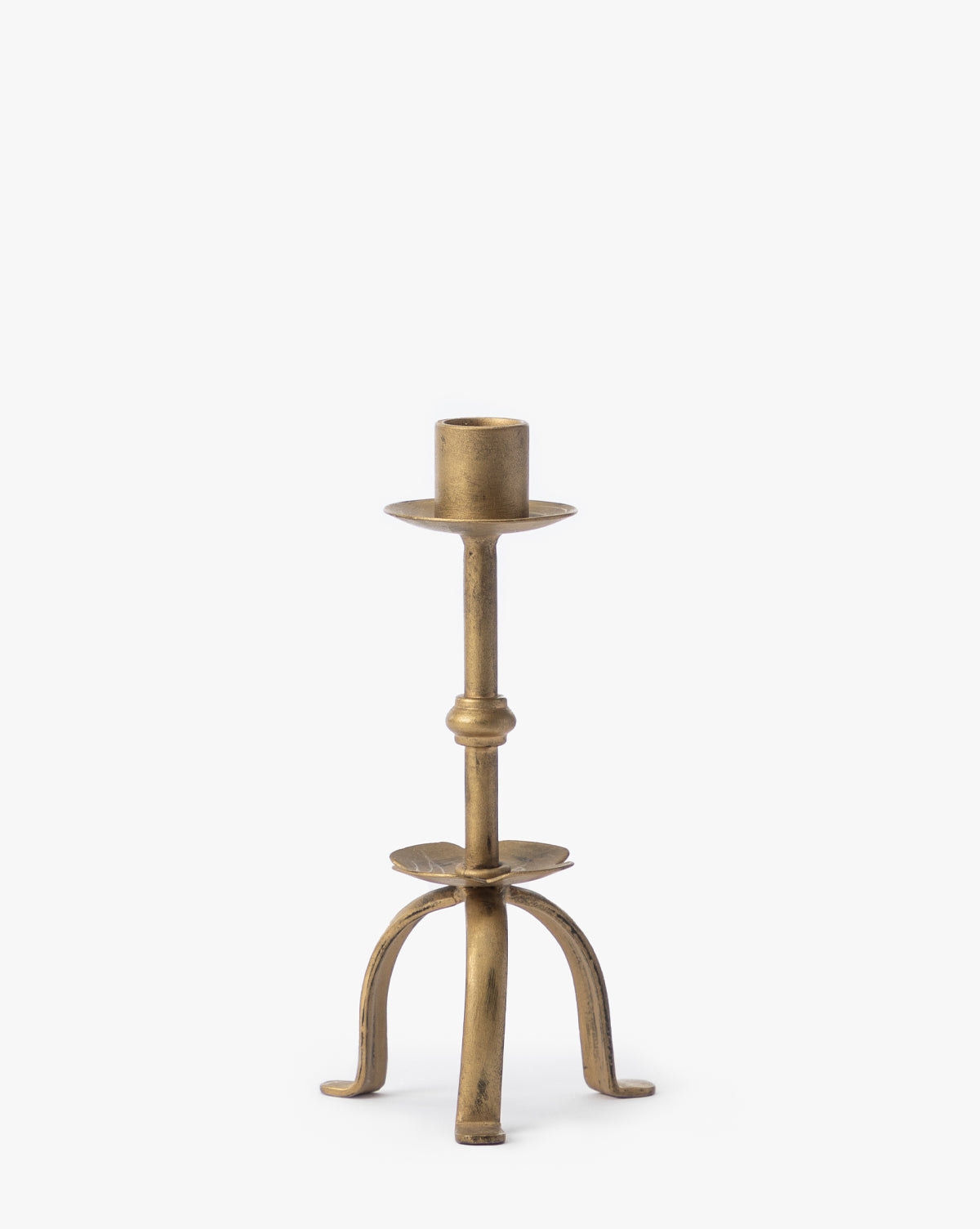 The Claridge Taper Holder features an antique brass finish, a single cylindrical socket, and three curved legs—ideal as mantel decor.