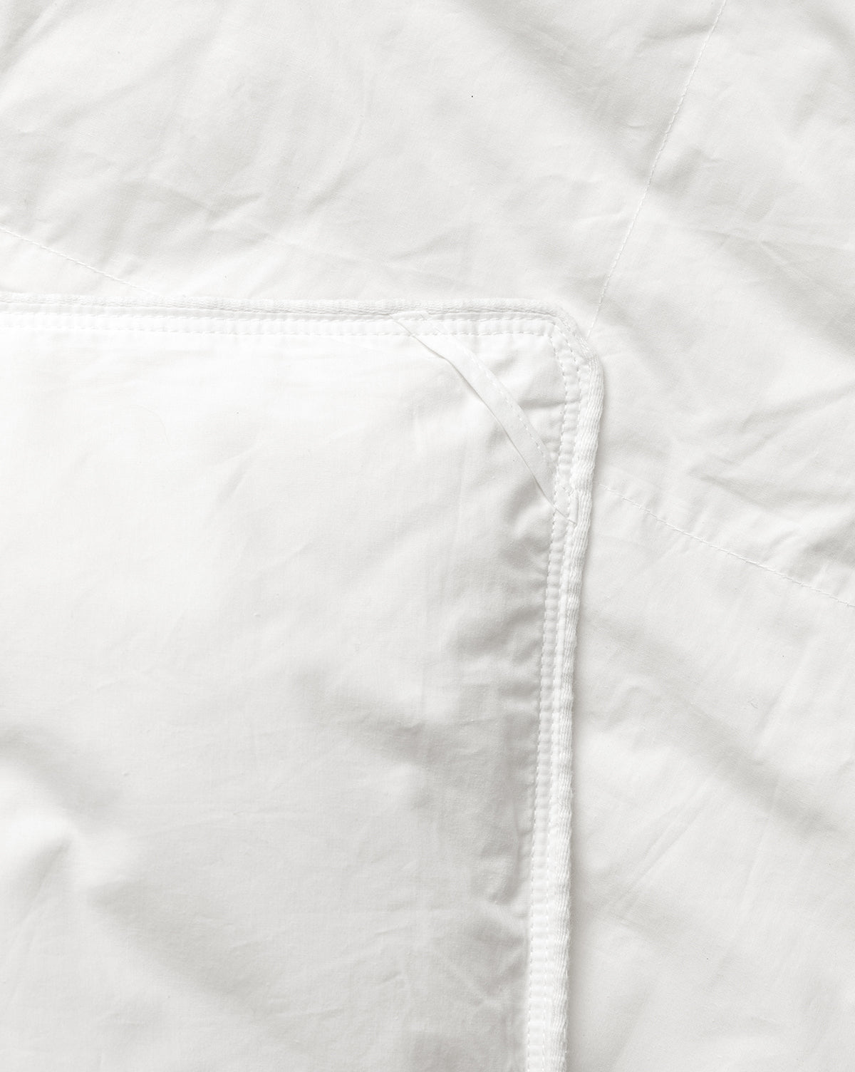 Close-up of a white quilted jacket with a focus on the stitching detail from McGee & Co.