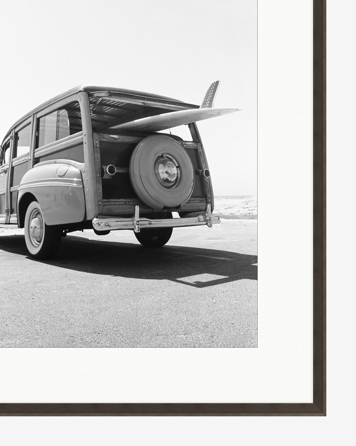 Classic Surf is a museum-quality black and white giclee print featuring a vintage station wagon by the beach with a surfboard in the trunk, evoking timeless nostalgic surf vibes.