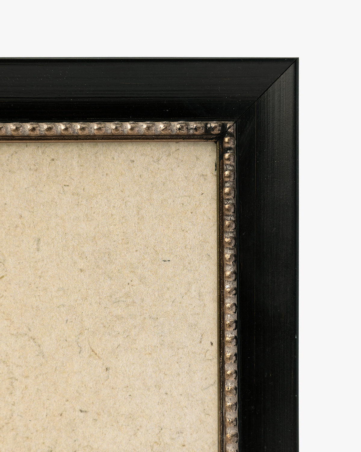 Close-up of the top right corner of a black frame with decorative beading and a textured beige background—ideal for displaying Clouded Island as a giclée on paper or highlighting its detailed landscape features, by McGee & Co.