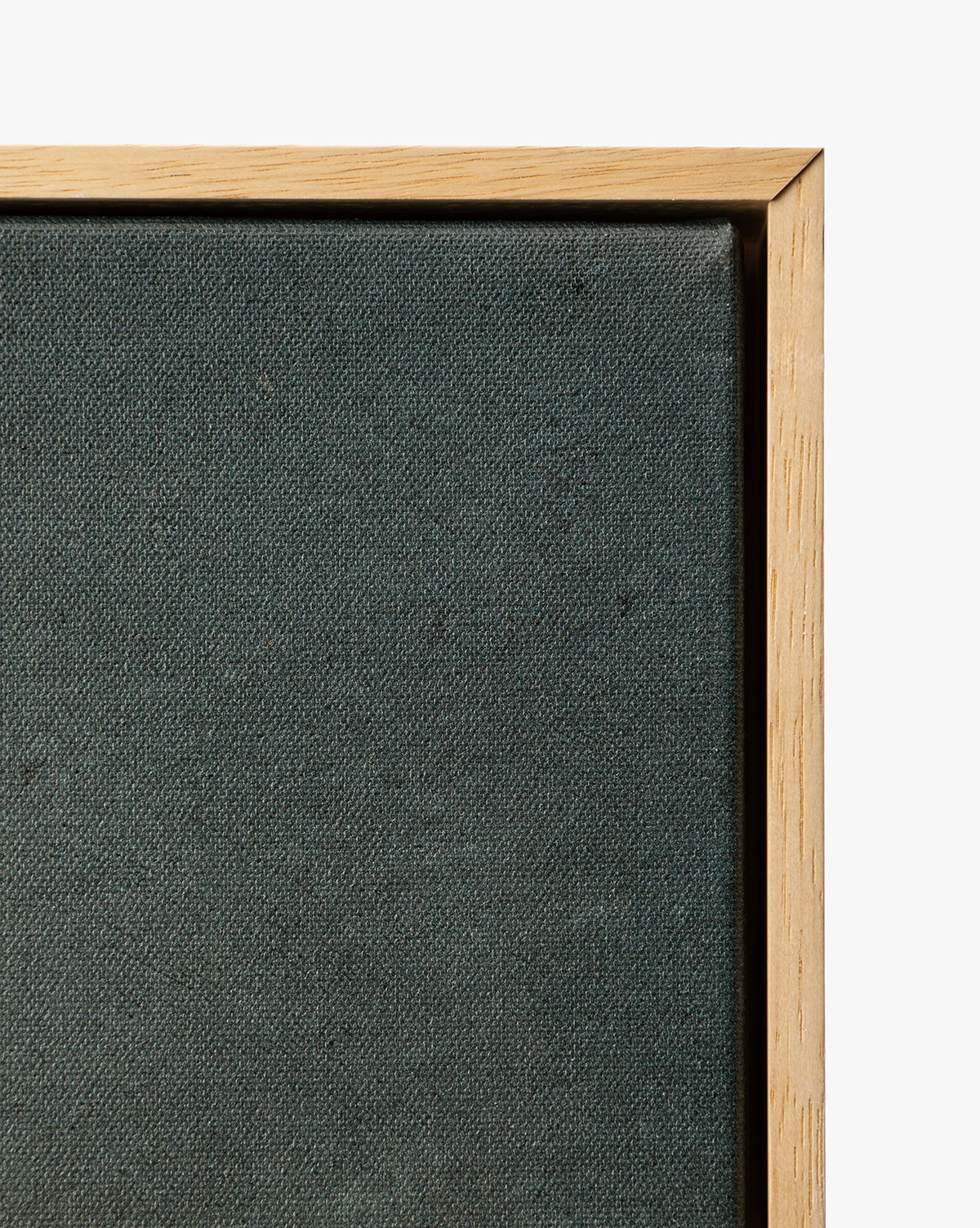 Close-up of the top right corner of the Clouds Over Mountains stretched dark canvas in a light wooden frame, showcasing this moody framed art against a white background, by McGee & Co.