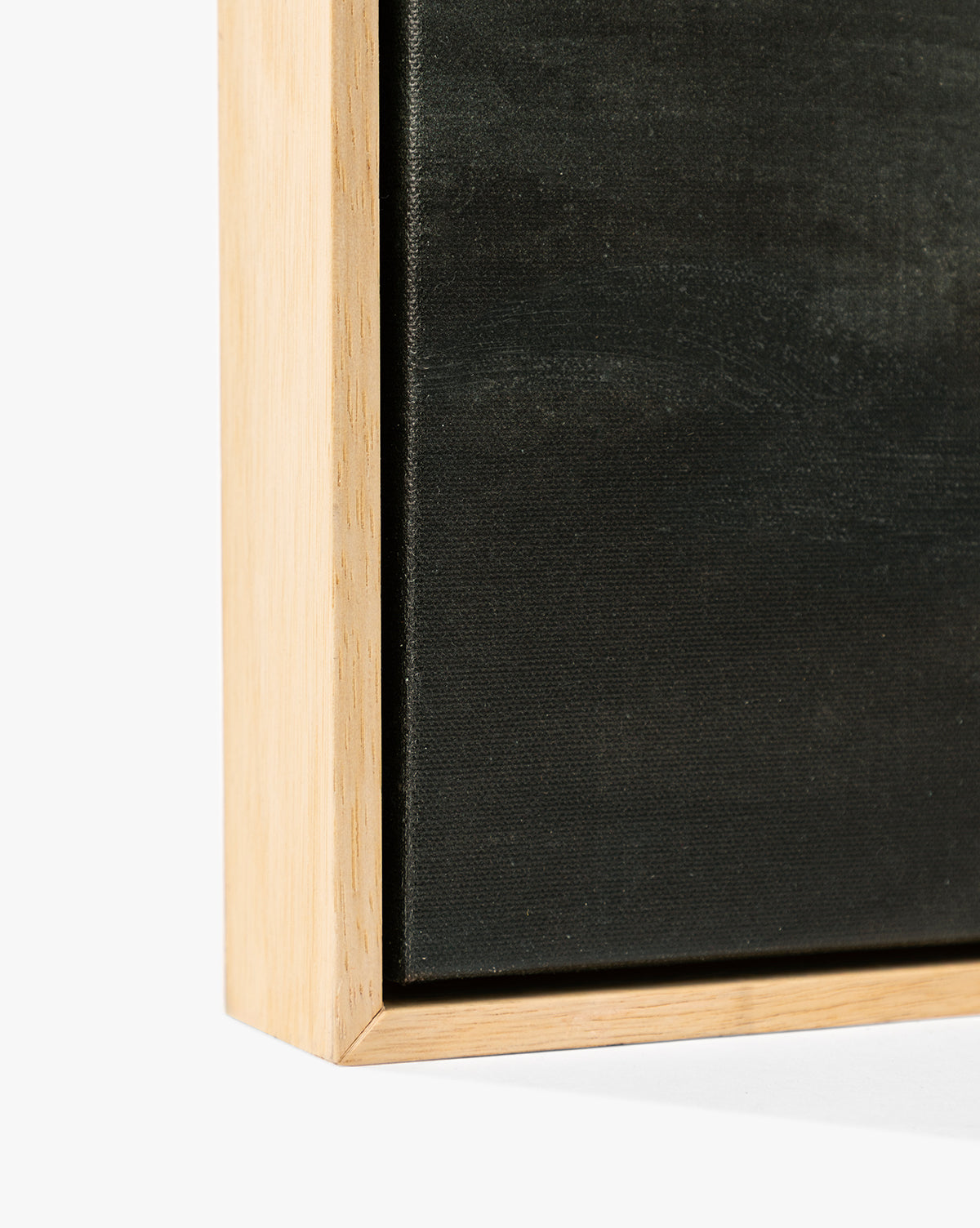 Close-up of the corner of Clouds Over Mountains, a black canvas in a light wood frame against a white backdrop—an elegant detail perfect for fans of moody, atmospheric wall art, by McGee & Co.