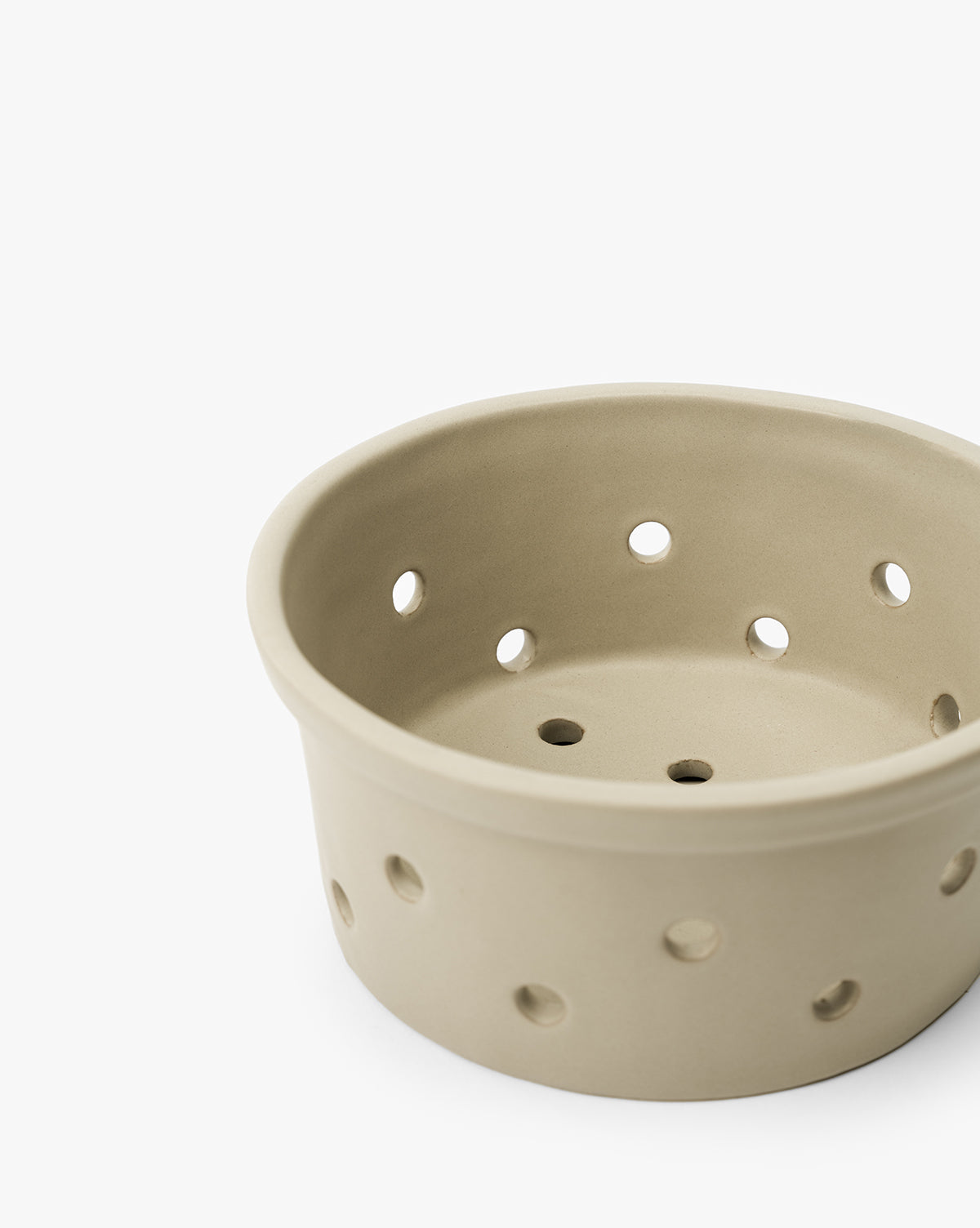 The Coen Berry Bowl, in beige with a matte finish and multiple round holes on its sides and bottom, is set against a white background by McGee & Co.