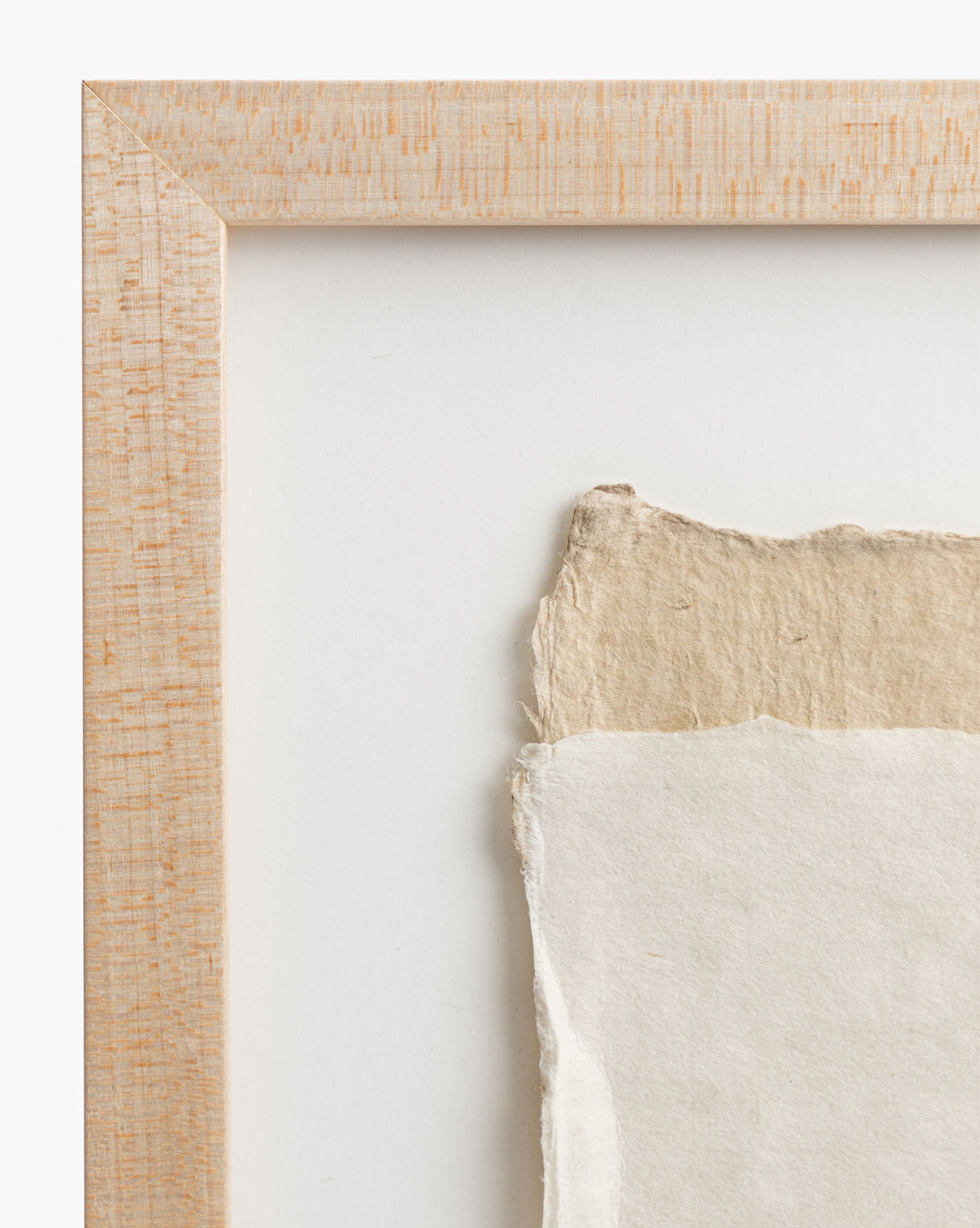 Close-up of Collage 2: a maple wood frame encases textured, torn-edge beige and white handmade paper art, layered on a white background—ideal as neutral wall decor.