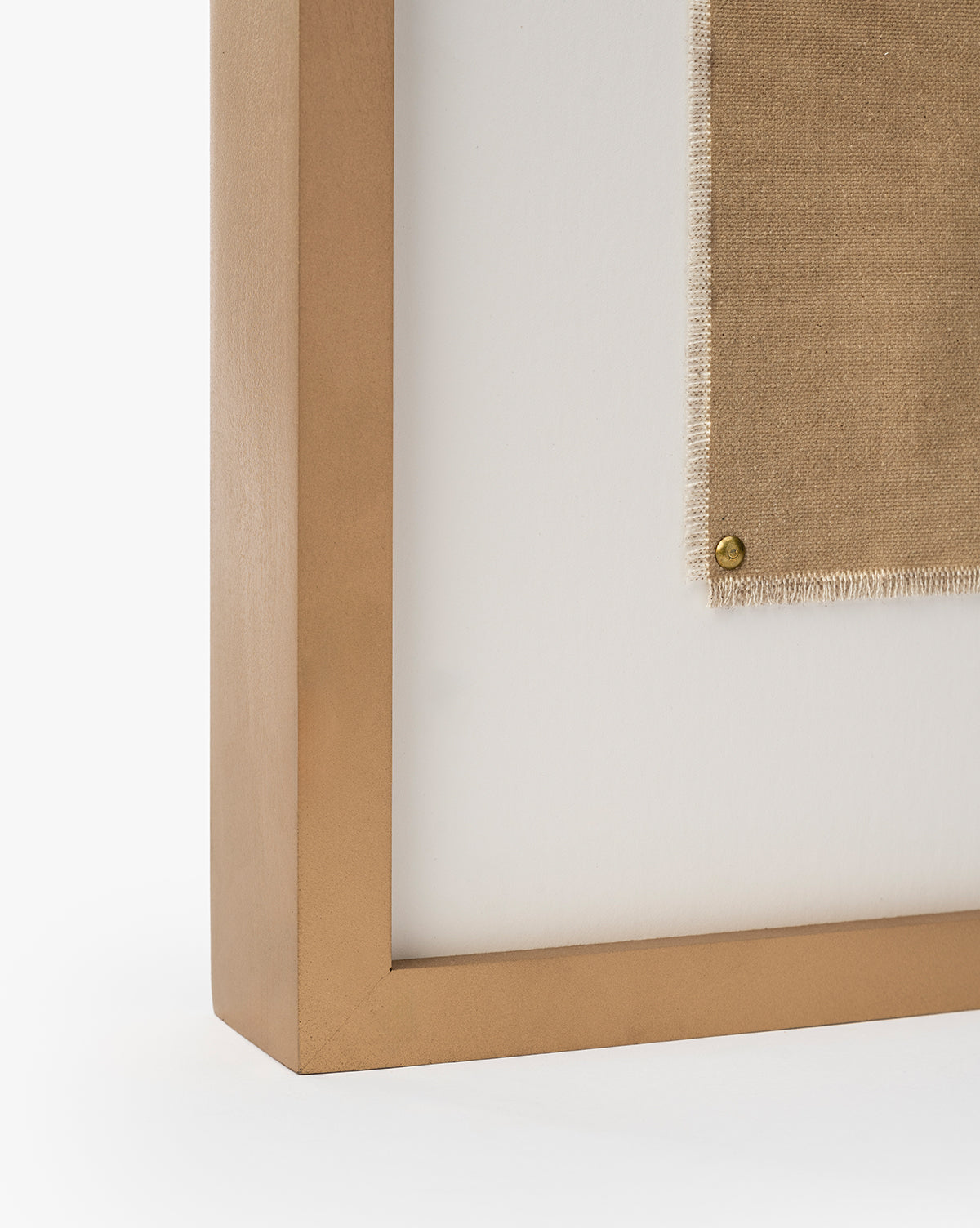 A close-up of Consider the Wildflowers by Katie Mulder, a beige fabric artwork held in a gold-colored maple frame and secured with a round brass tack against a white background, by McGee & Co.