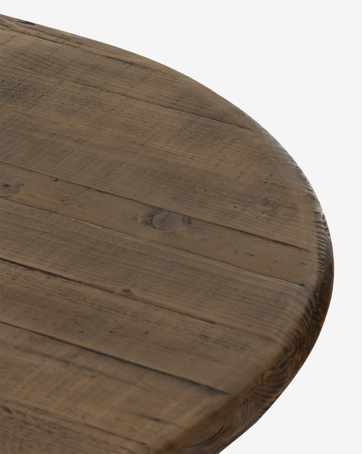 A close-up of the Constance Dining Table’s round solid pine tabletop highlights its visible grain, knots, and plank lines, showcasing a rustic, modern farmhouse finish against a white background, by McGee & Co.