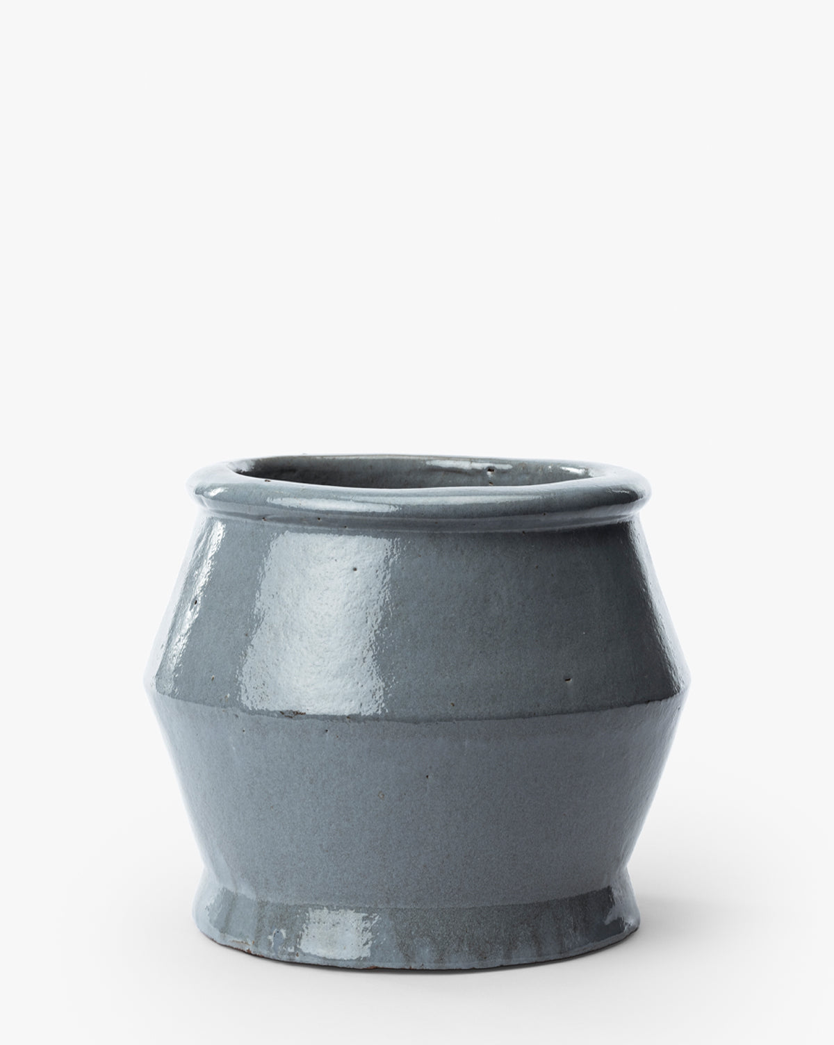 The Corsica Pot is a glossy, deep bluish-gray ceramic stoneware planter featuring a wide circular opening, slightly flared rim, angled sides, and a narrow base, displayed against a white background, by McGee & Co.