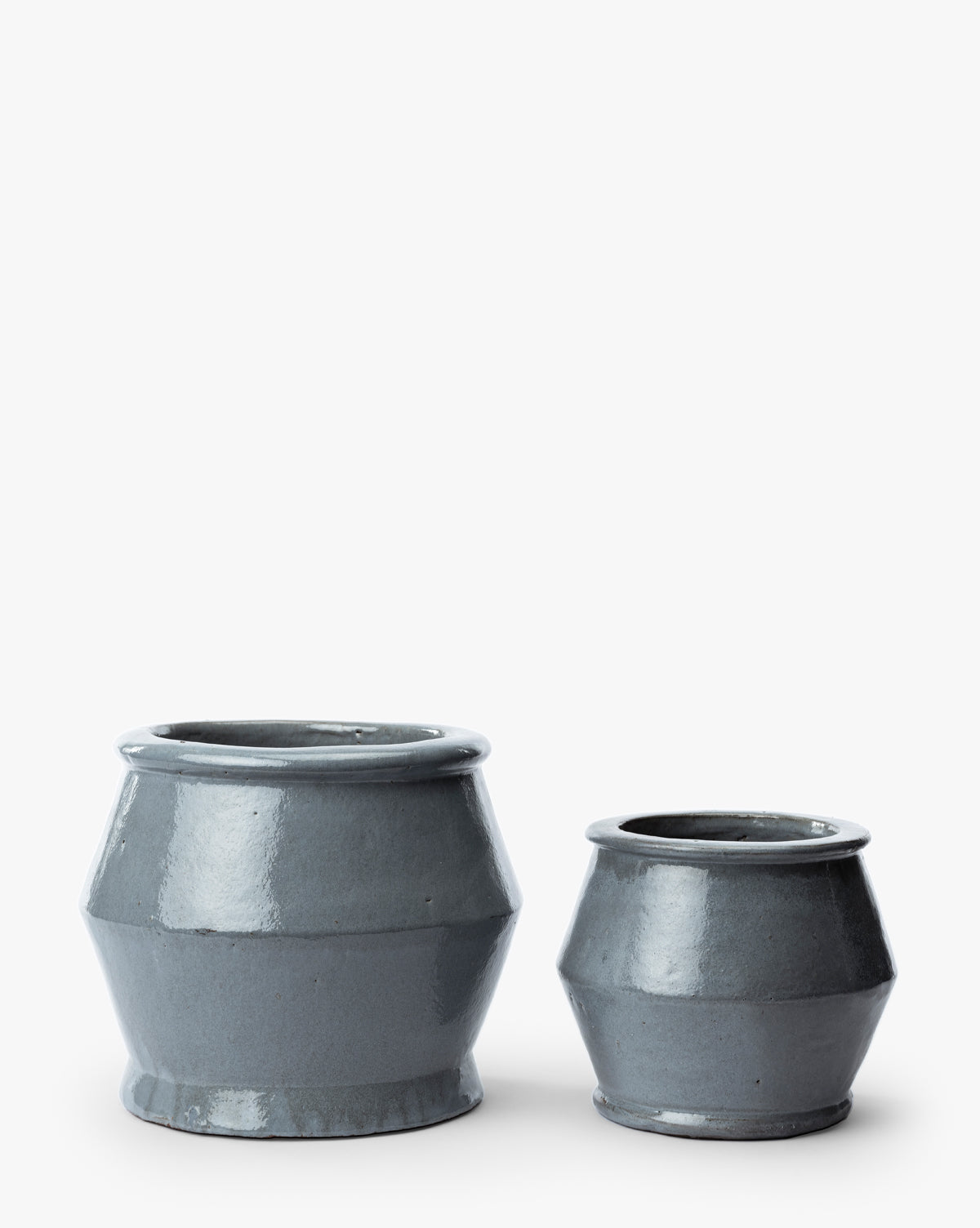 Two Corsica Pot planters made of glossy, dark gray ceramic stoneware—one large and one small, both with wide openings and flared sides—are displayed against a plain white background, by McGee & Co.