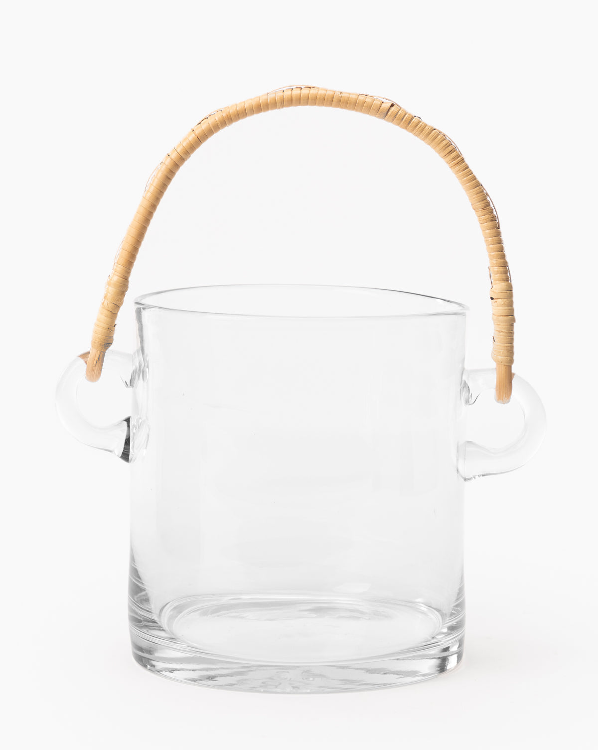 The Crockett Rattan Ice Bucket features clear glass, two side handles, and an arched rattan-wrapped handle on top, elegantly displayed against a plain white background by McGee & Co.