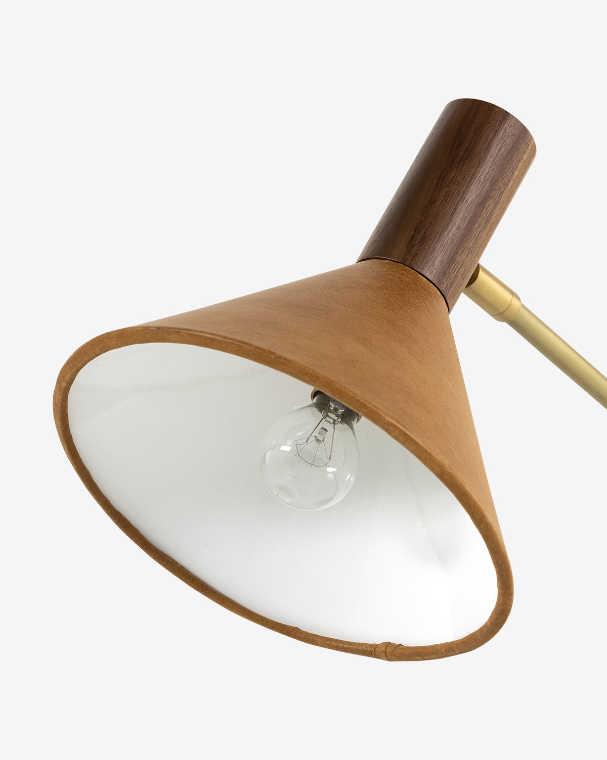A close-up of the Cullen Task Lamp featuring a conical top-grain leather shade, white interior, exposed bulb, wooden fixture, and brass arm on a plain white background, by McGee & Co.