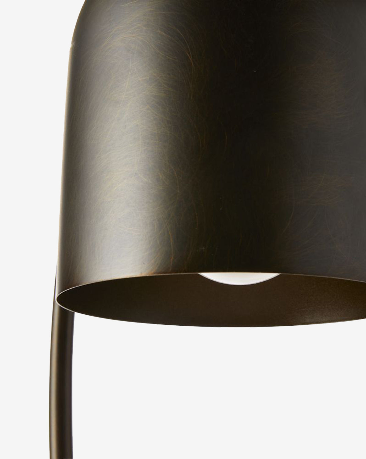 Close-up of the Daley Desk Lamps dark bronze-finished shade, showcasing its smooth dome shape, part of the curved stand, and a hint of the bulb inside—all set against a white background by McGee & Co.
