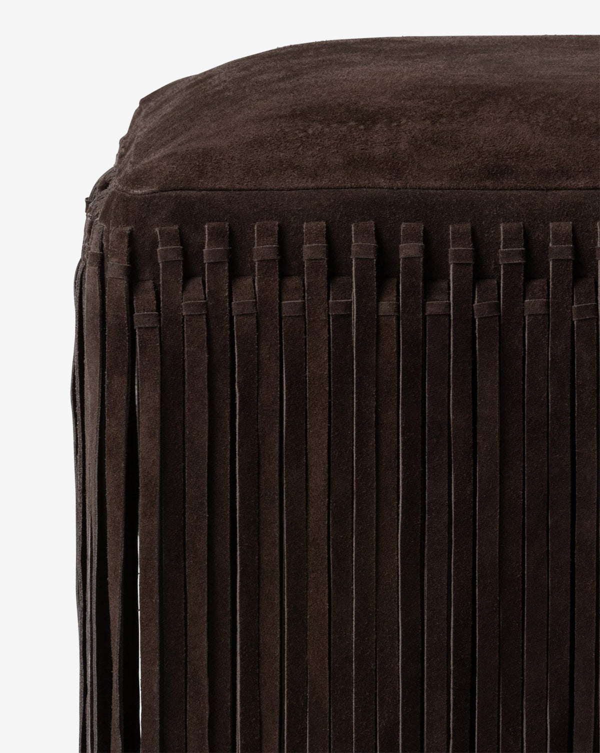 Certainly! Here’s your revised sentence with the exact string McGee & Co. blended at the end: Close-up of the Made Goods Damian Ottoman, a dark brown suede piece in camel hue with long vertical fringe detailing, shown against a plain white background, McGee & Co.