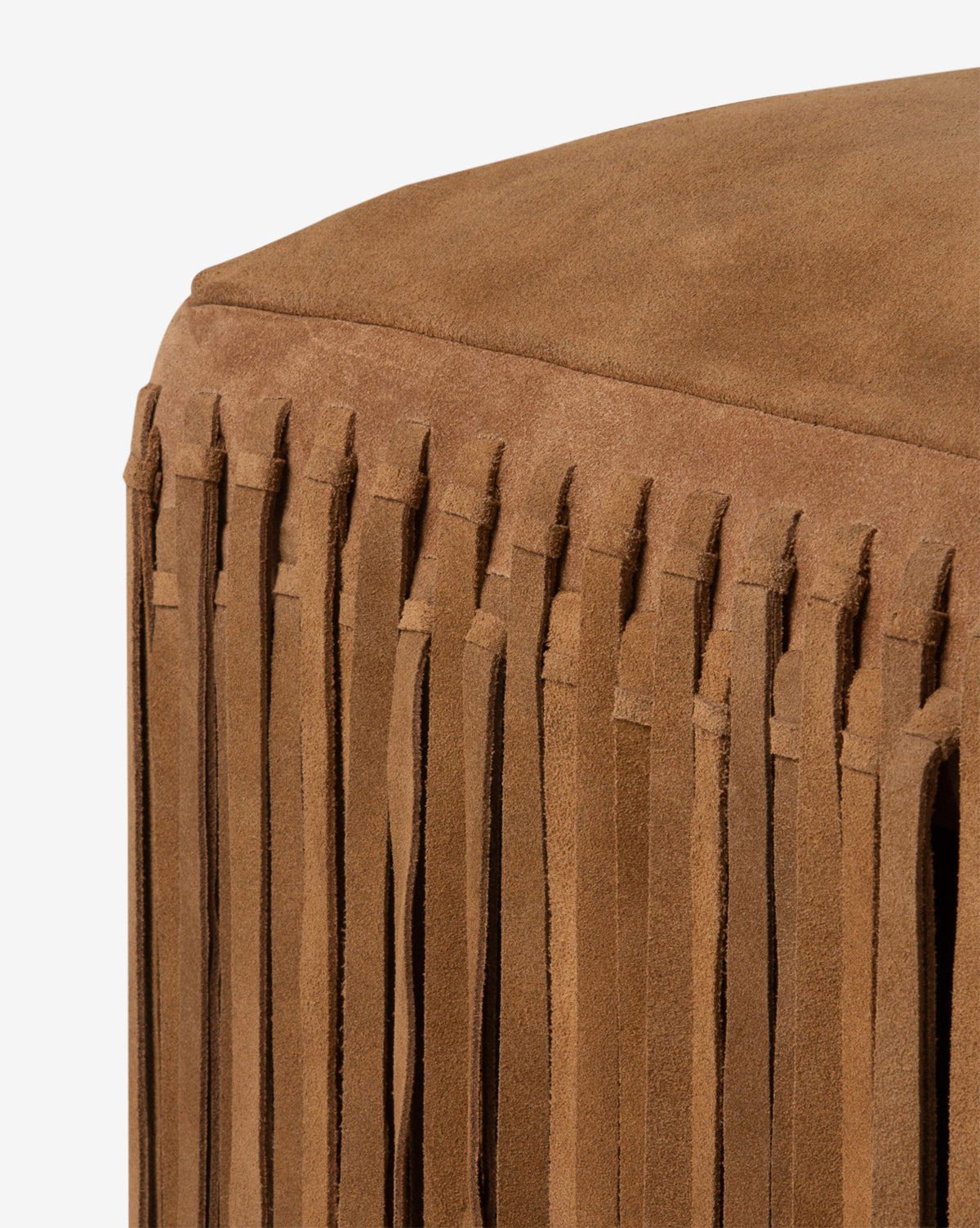 The Damian Ottoman by Made Goods is shown in a rich camel suede with long fringe detailing along the side, set against a white background. McGee & Co.