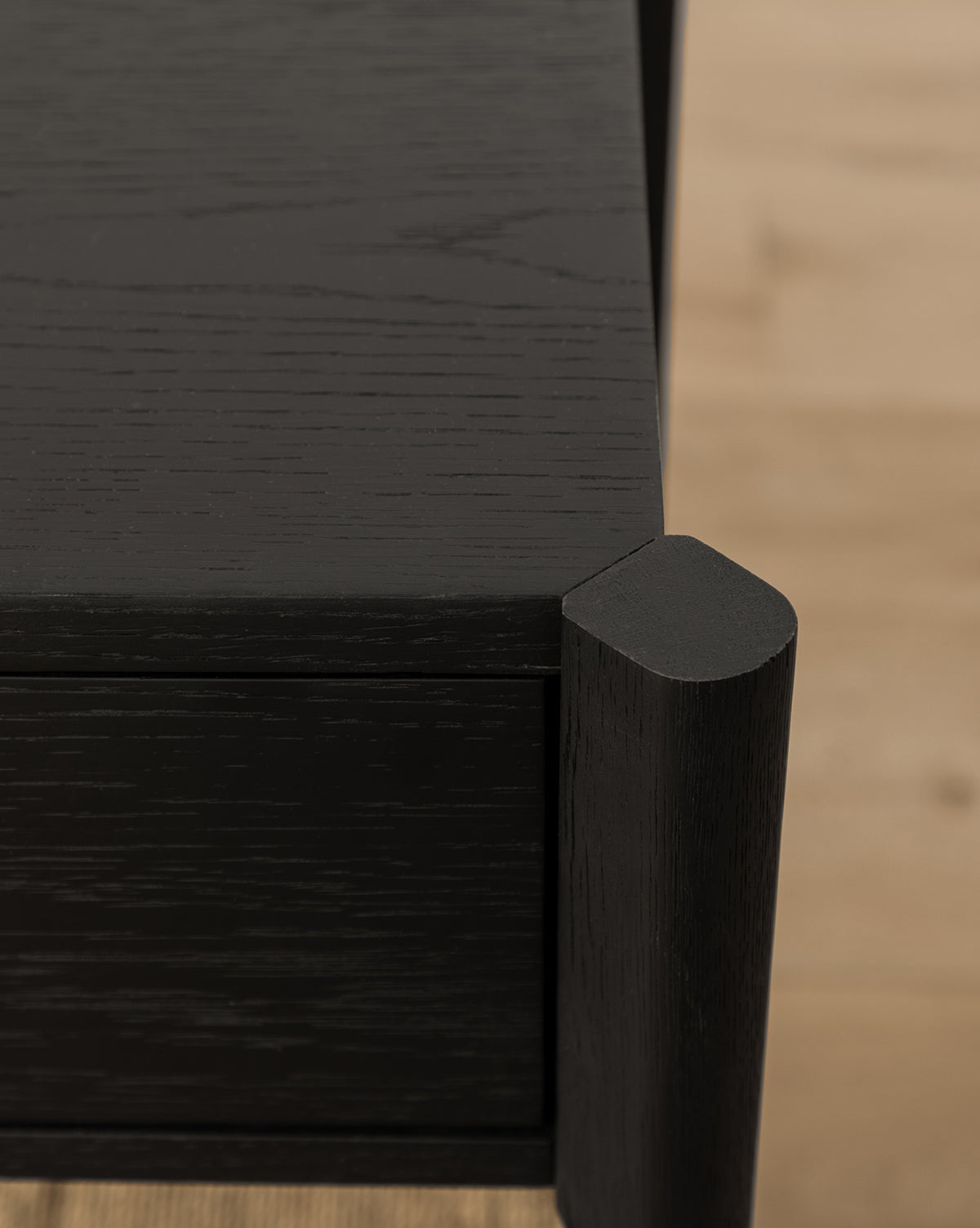 Close-up of the Dana 2-Drawer Console’s rounded corner, set on a light wood floor—ideal for adding stylish entryway decor, by McGee & Co.