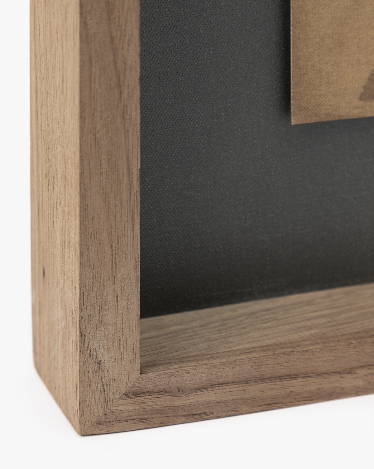 Close-up of the rustic walnut frame around Dappled, featuring a black background and a glimpse of moody abstract art, with attention to the canvas’s distinctive deckled edges, by McGee & Co.