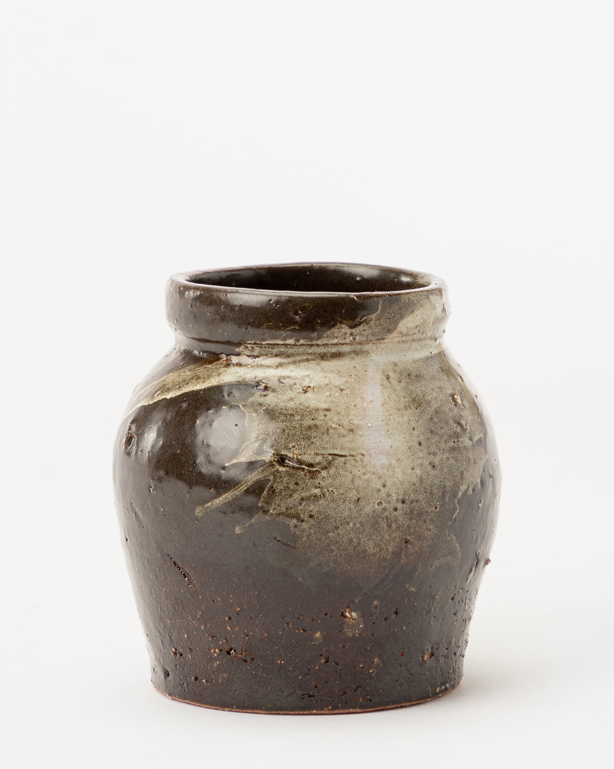 The Dark Glazed Ceramic Vase features a rustic, dark brown, glossy finish with an uneven rounded shape and lighter glaze drips near the top, creating a classic ceramics look that stands out against a white background.