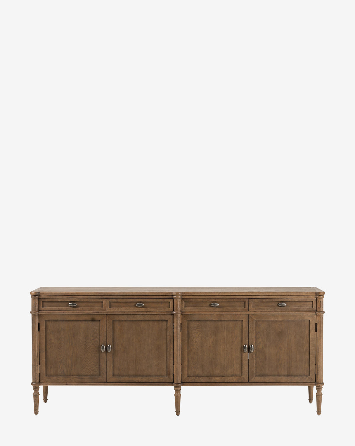 The Dixon Sideboard features four front doors, four drawers, and aged brass hardware, by McGee & Co. This oak sideboard stands on six tapered legs and is showcased against a plain white background.