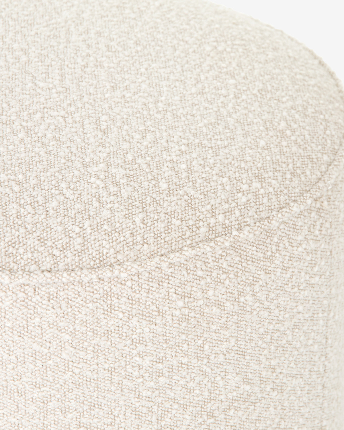 Close-up of a textured light beige fabric cushion on the Dawson Ottoman, showing fine woven details and a visible seam along the top edge above its sleek wood base, by McGee & Co.