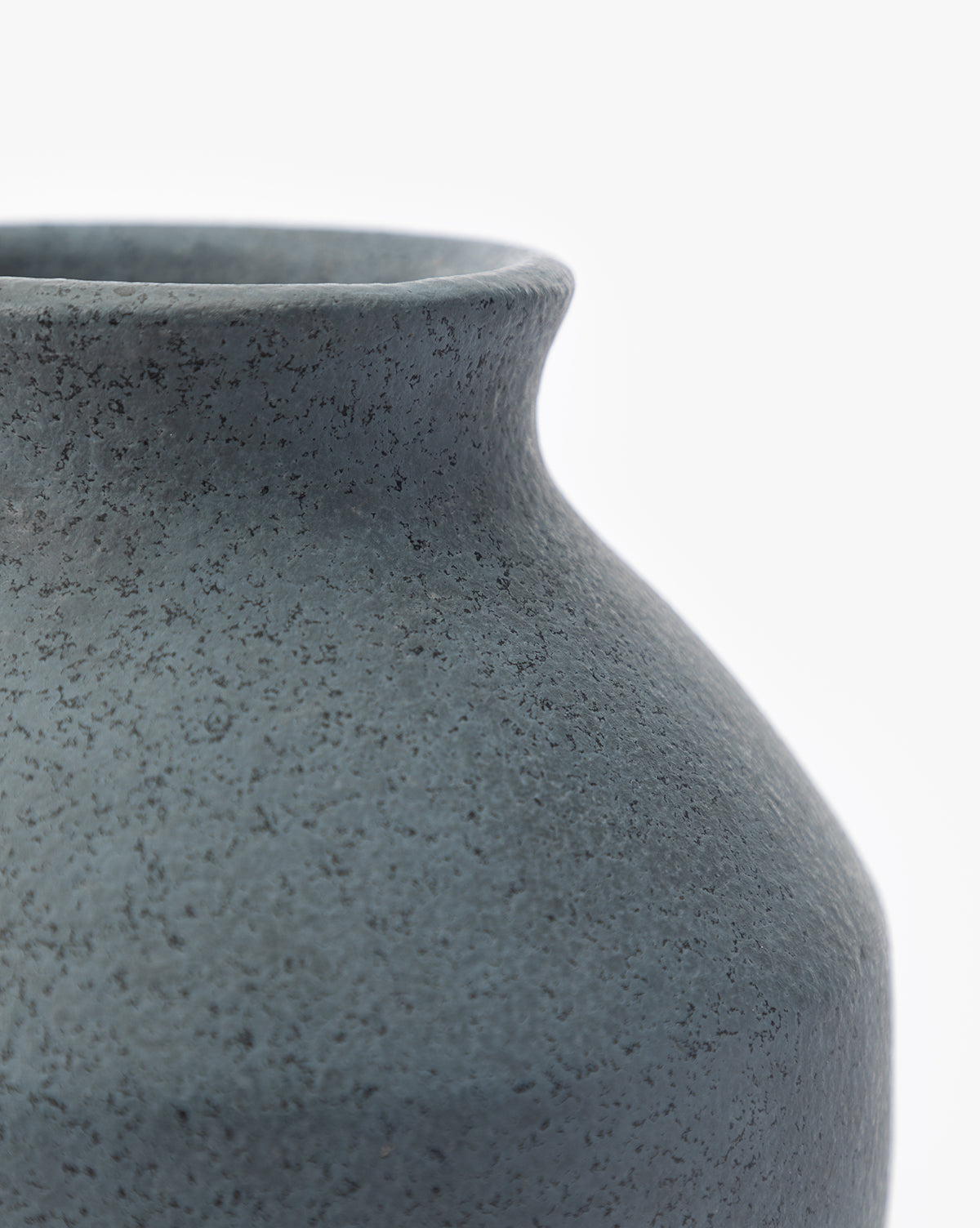 Close-up of the Delgado Vase, featuring its textured matte dark gray surface, with a focus on the round body and narrow neck set against a plain white background, by McGee & Co.