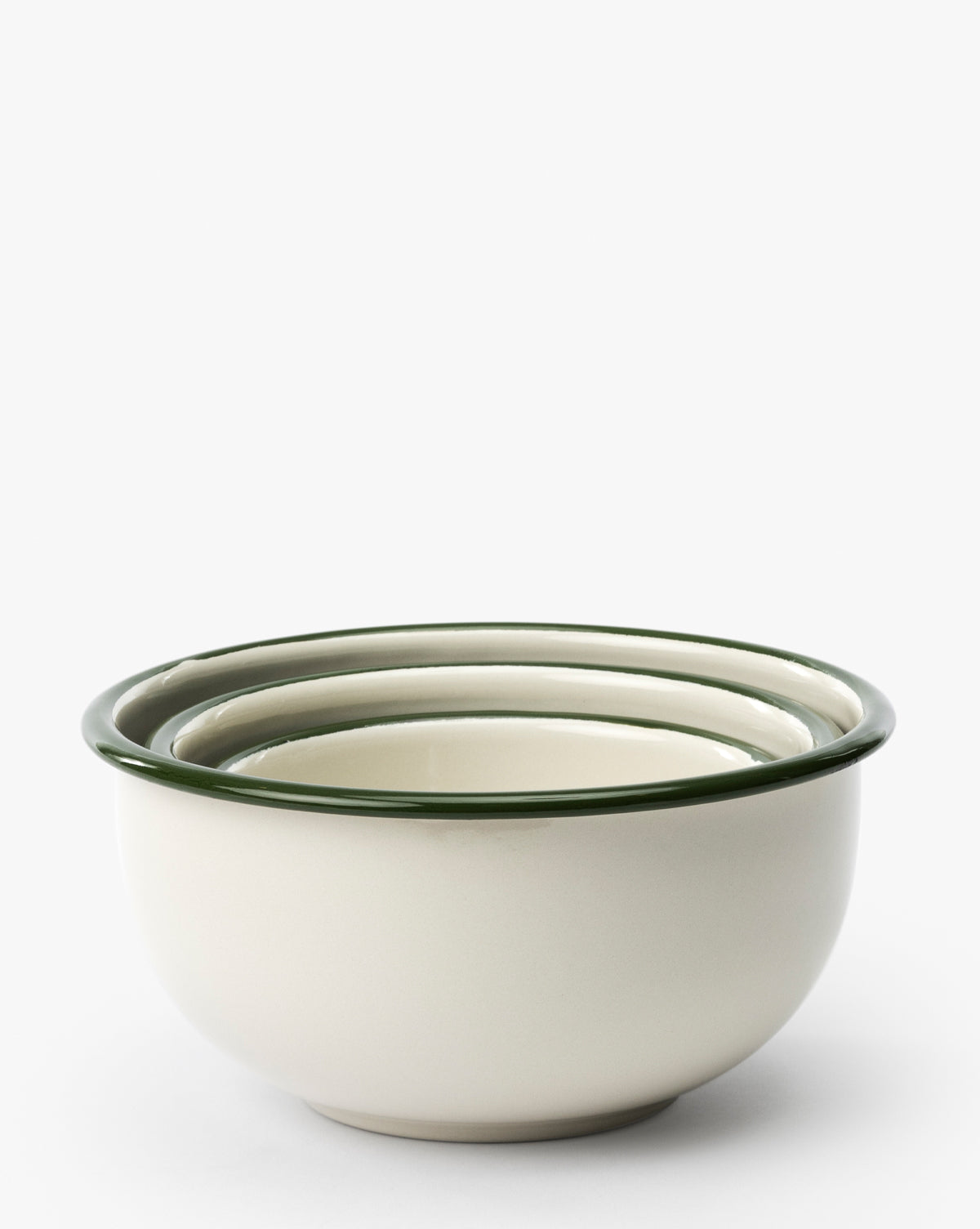 The Delia Bowls (Set of 3) features three cream-colored stoneware bowls with dark green rims, nested together against a plain white background for a charming vintage-inspired look, by McGee & Co.