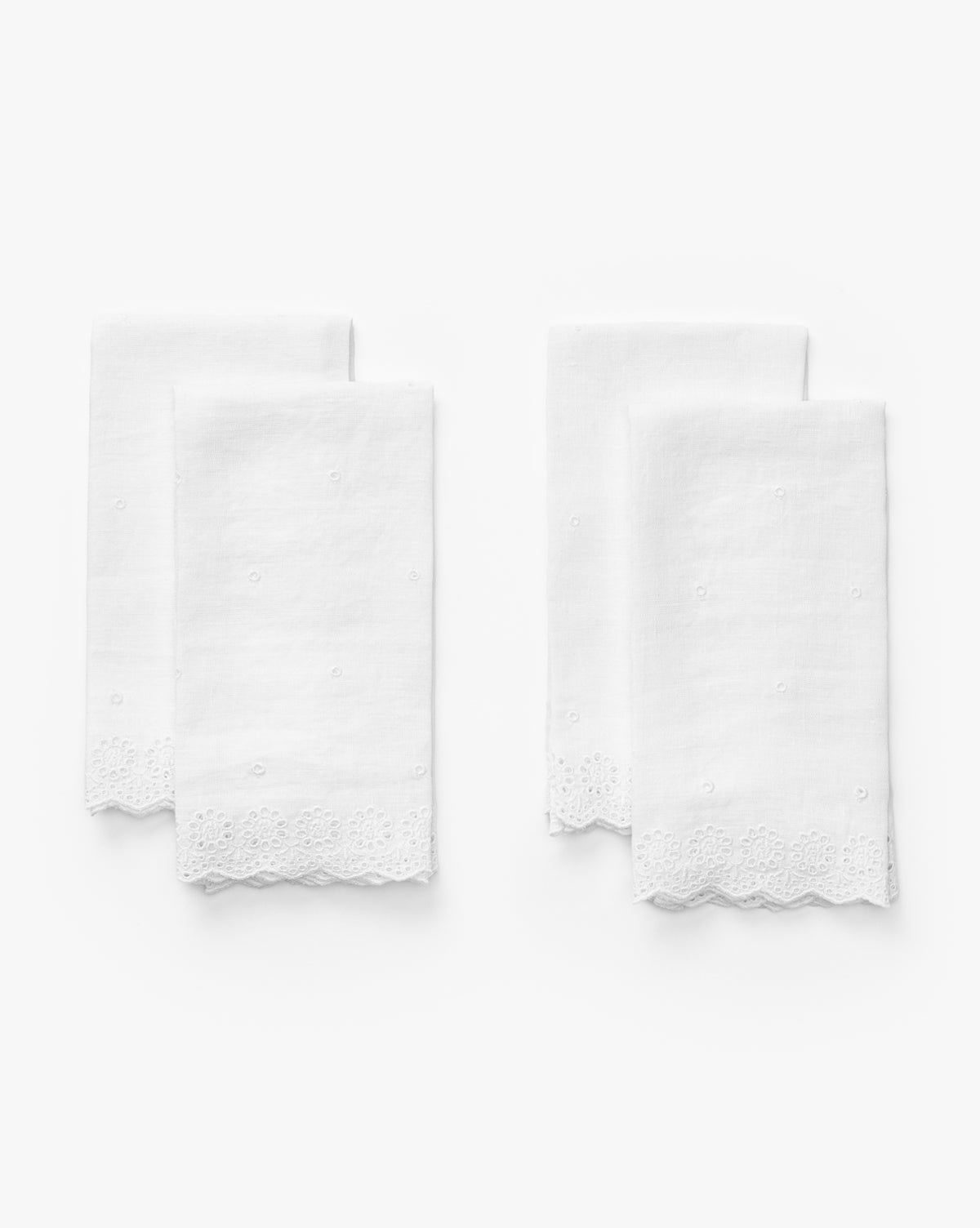 The McGee & Co. x Loeffler Randall Delilah Broderie Napkins (Set of 4) are white linen with delicate embroidery, broderie borders, and scalloped lace edges, neatly folded in pairs against a plain white background by McGee & Co.